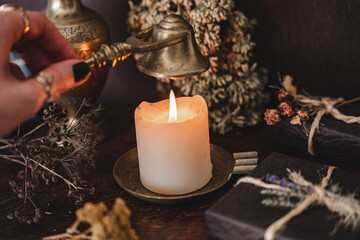 Wiccan witch putting out a white candle flame with antique brass gold colored wick snuffer. Casting...