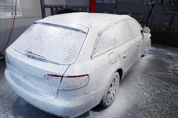 Car wash, a lot of active foam on the car and on the ground © Vladyslav