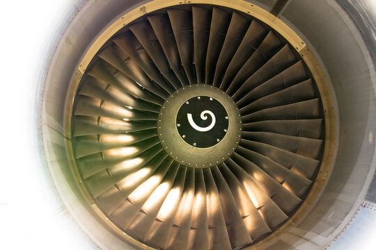 Close up of fan engine and turbine blades of modern civil passenger airplane illuminated beautiful light.