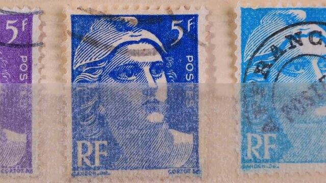 Postage stamp issued in France with image of the Marianne. From the series on Marianne type Gandon. Browsing a stockbook containing collection of canceled French stamps. Close-Up