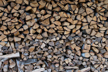 textured background of firewood from chopped wood for kindling and heating the house. woodpile with stacked firewood. birch texture. banner