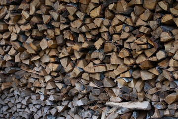 textured background of firewood from chopped wood for kindling and heating the house. woodpile with stacked firewood. birch texture. banner