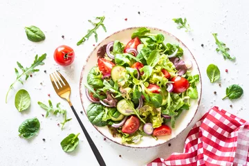 Foto op Aluminium Green salad on white background. Fresh salad leaves and vegetables in white plate. Healthy vegan food, diet food. Top view image. © nadianb