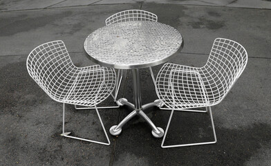 Table and two chairs outside in the rain