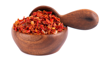 Dried red paprika flakes in wooden bowl and spoon, isolated on white background. Spices and herbs.