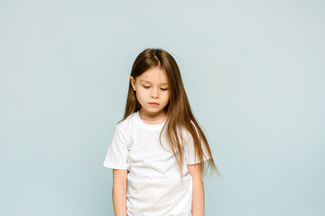 Photo of unhappy sad upset little girl feeling bored offended isolated on blue background