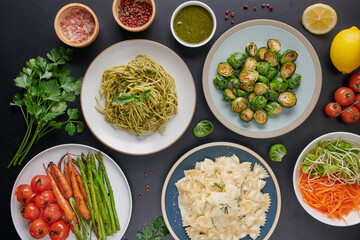 Pasta spaghetti with zucchini, basil, cream and cheese on stone table. Vegetarian vegetable pasta. Three Colors Rotini Pasta. Tasty appetizing classic italian spaghetti pasta with tomato sauce. salad.
