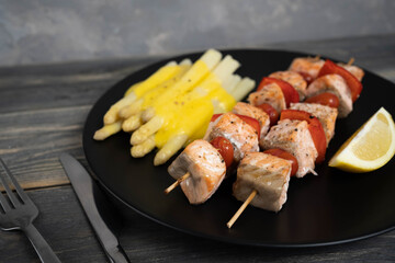 Baked salmon with asparagus on gray background. Mediterranean diet concept. White asparagus with hollandaise souce.