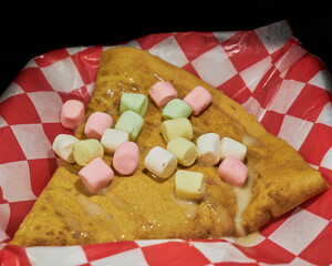 Making delicious crepes on a grill with fruit and chocolate