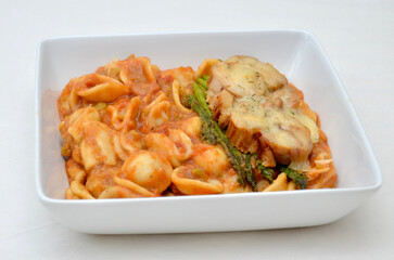 A meal of Baked Tuna with Melted Cheese, Sautéed Asparagus, and Orecchiette Pasta in Homemade Brown Pea Sauce.