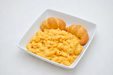 A meal of Mac and Cheese (with Shell Pasta) and Baked Croissants.