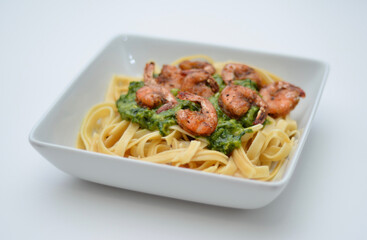 Grilled shrimp tail-on on pesto. On a bed of fettuccini.