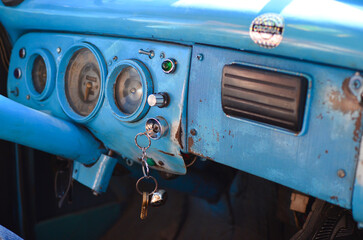 The interior dashboard area of a vintage 1950s car in Cuba featuring jerry-rigged non-original equipment.