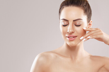  Portrait of beauty model with natural nude make up and touching her face. Spa, skincare and...