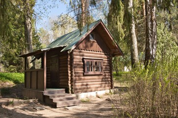 Fototapeta na wymiar Small wooden house in forest. Forester or hunter wooden hut among the trees at summer.