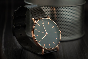 Elegant metallic black watch on reflective base and metallic background
