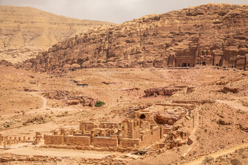 Ancient Nabataean Royal tombs in the background and ruins of grand temple in the foreground, Petra,...