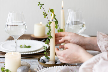 Obraz na płótnie Canvas Rustic zero waste wedding decor with natural elements. Wooden table, candles, linen napkins, branches with green leaves. Eco-friendly decoration for the special dinner. Romantic and cozy place