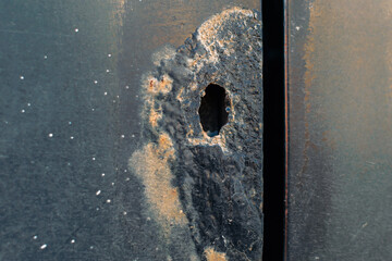 Deformation in the form of a through hole on the car body with elements of corrosion
