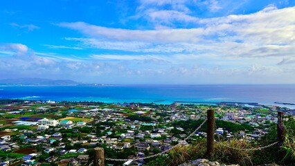 城山の頂上から見える伊江島の街並みと晴天の空と海