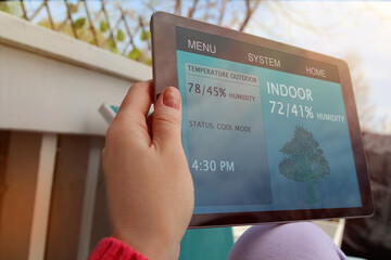 Woman is Adjusting a  temperature using a tablet with smart home app