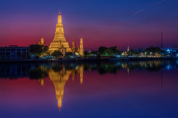 Fototapeta na wymiar View of the Wat Arun temple at sunset with reflections in the water