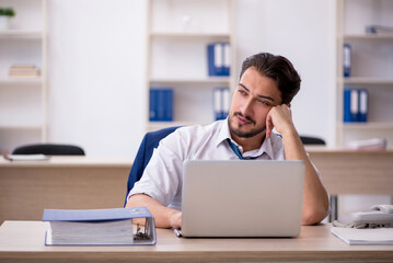 Naklejka premium Young male employee working in the office