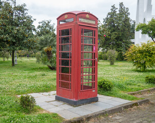 Red telephone box. Fake phone. Scenery in the city park. entertainment world