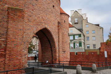 Warsaw, Poland, 13 October 2021: Barbican complex network of historic fortifications between Old and New Town, red brick fort wall with towers, major tourist attraction at sunny autumn day, city gate