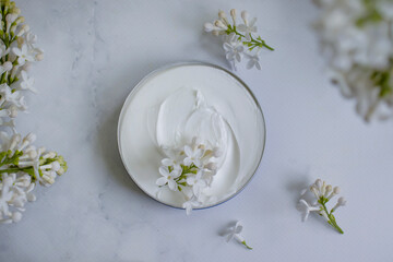 Fototapeta na wymiar cream cosmetic lilac flower background