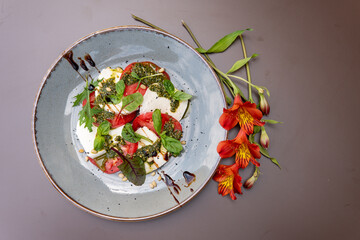 Mozzarella with tomatoes under pesto sauce