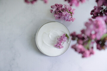 cream cosmetic lilac flower background