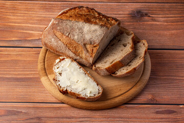 homemade bread with buttered butter on a wooden background
