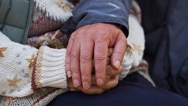 Support in illness concept. Wrinkled hands of two caucasian elderly senior people touching each other. High quality photo