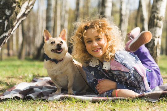 young charming Caucasian girl resting in the park with her beloved dog full shot outdoors pet concept. High quality photo