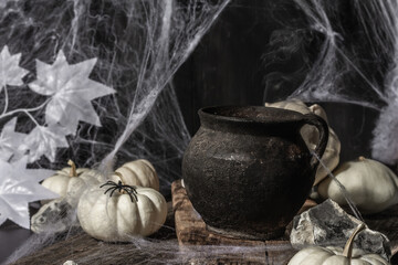 Halloween composition with witch's pot, pumpkins, bat, ghost, spider, and cobwebs