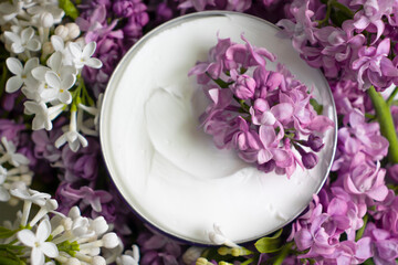 Obraz na płótnie Canvas cream cosmetic lilac flower background