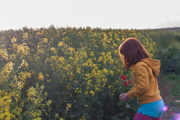 Niña en campo de flores amarillas