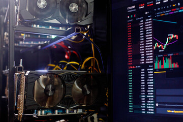 Graphics cards in rig for ethereum mining farm on background Stock Market ETH Chart