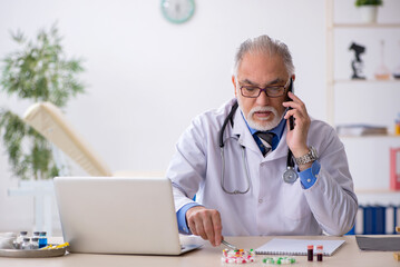 Old male doctor pharmacist working at the lab