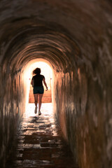 photo of a woman running in a tunnel 