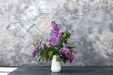 Fototapeta na wymiar Branches of fresh purple lilac in white vase