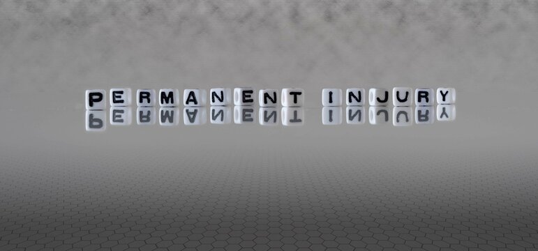 Permanent Injury Word Or Concept Represented By Black And White Letter Cubes On A Grey Horizon Background Stretching To Infinity