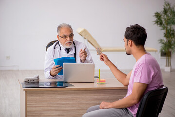 Young male patient visiting old male doctor