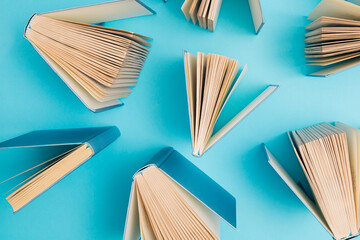 Creative pattern made of pastel blue books on bright blue background. Education, knowledge or Nature concept. Flat lay.