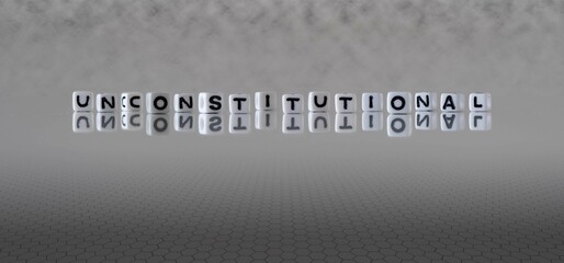 unconstitutional word or concept represented by black and white letter cubes on a grey horizon...