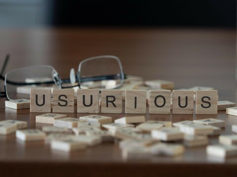 usurious word or concept represented by wooden letter tiles on a wooden table with glasses and a book