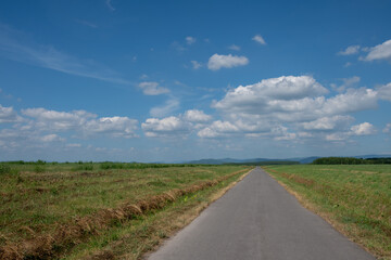 緑の草原を通る真っ直ぐな道路
