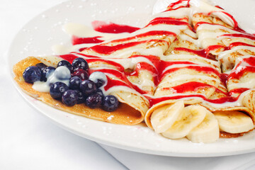 Rolled french crepes with blueberry banana