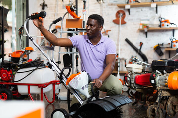 African-american man selecting new hardware in gardening tools shop.